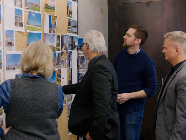 architects looking at project images at a pin-up board