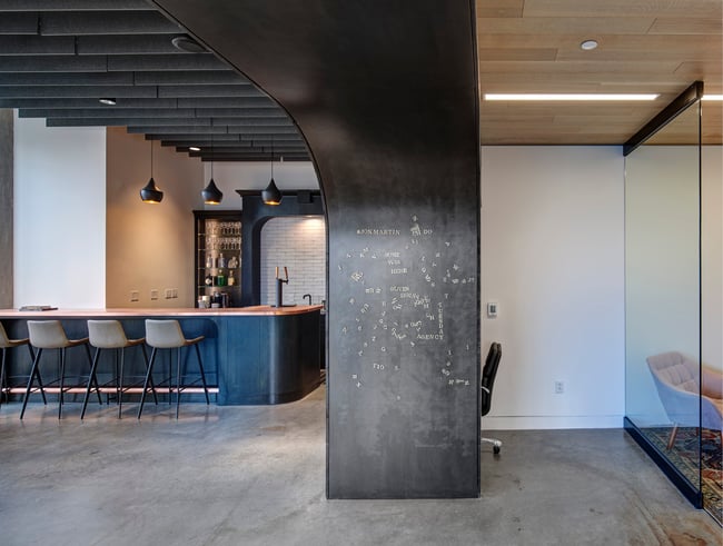 a contemporary office with concrete floors, metal wall details, and a wood ceiling finish