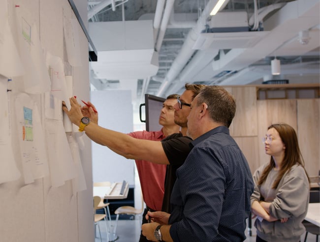 an architectural project manager reviewing design plans at a pin-up board